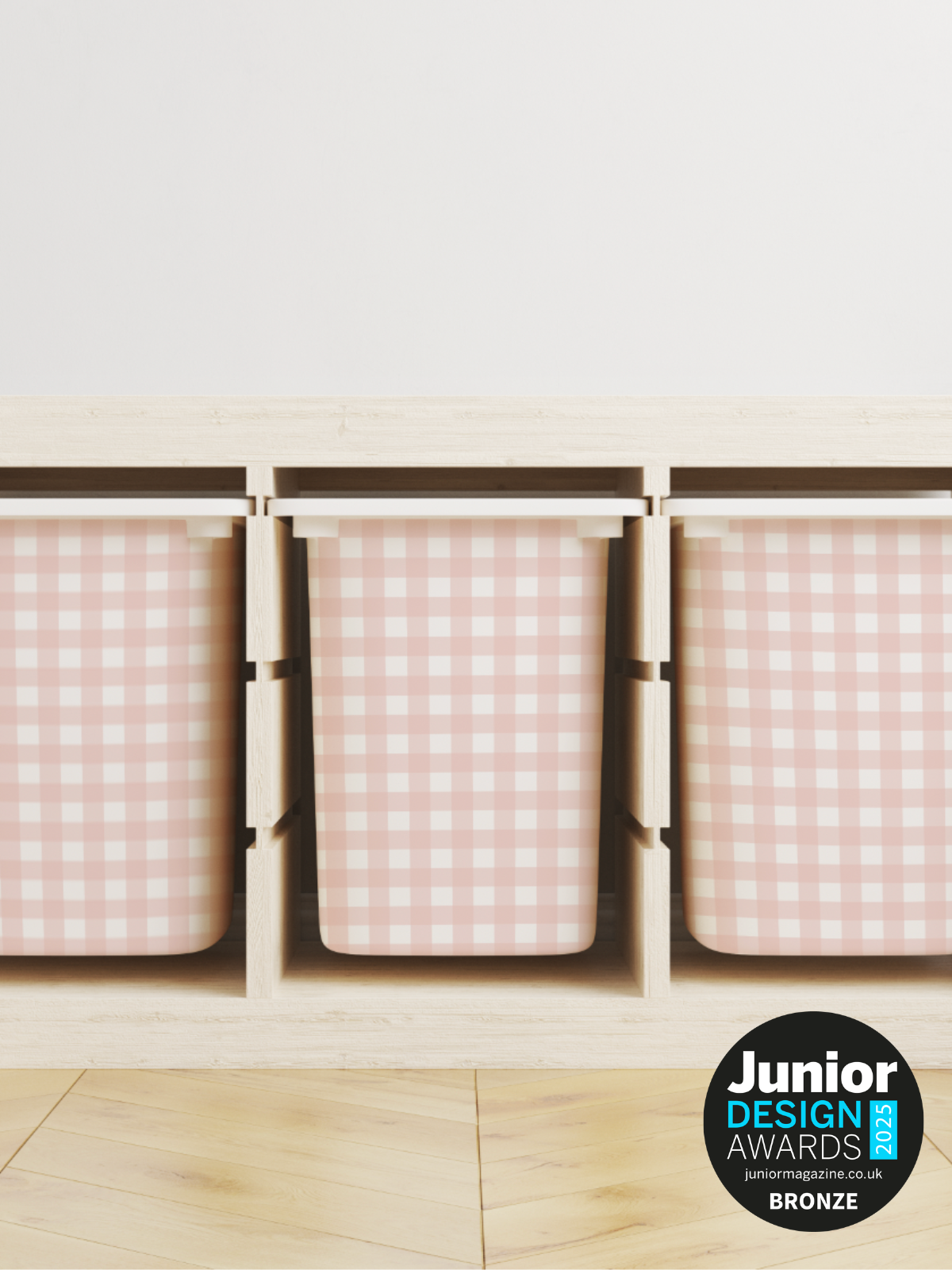 Wooden storage unit with three pink checkered bins on a light wooden floor.
