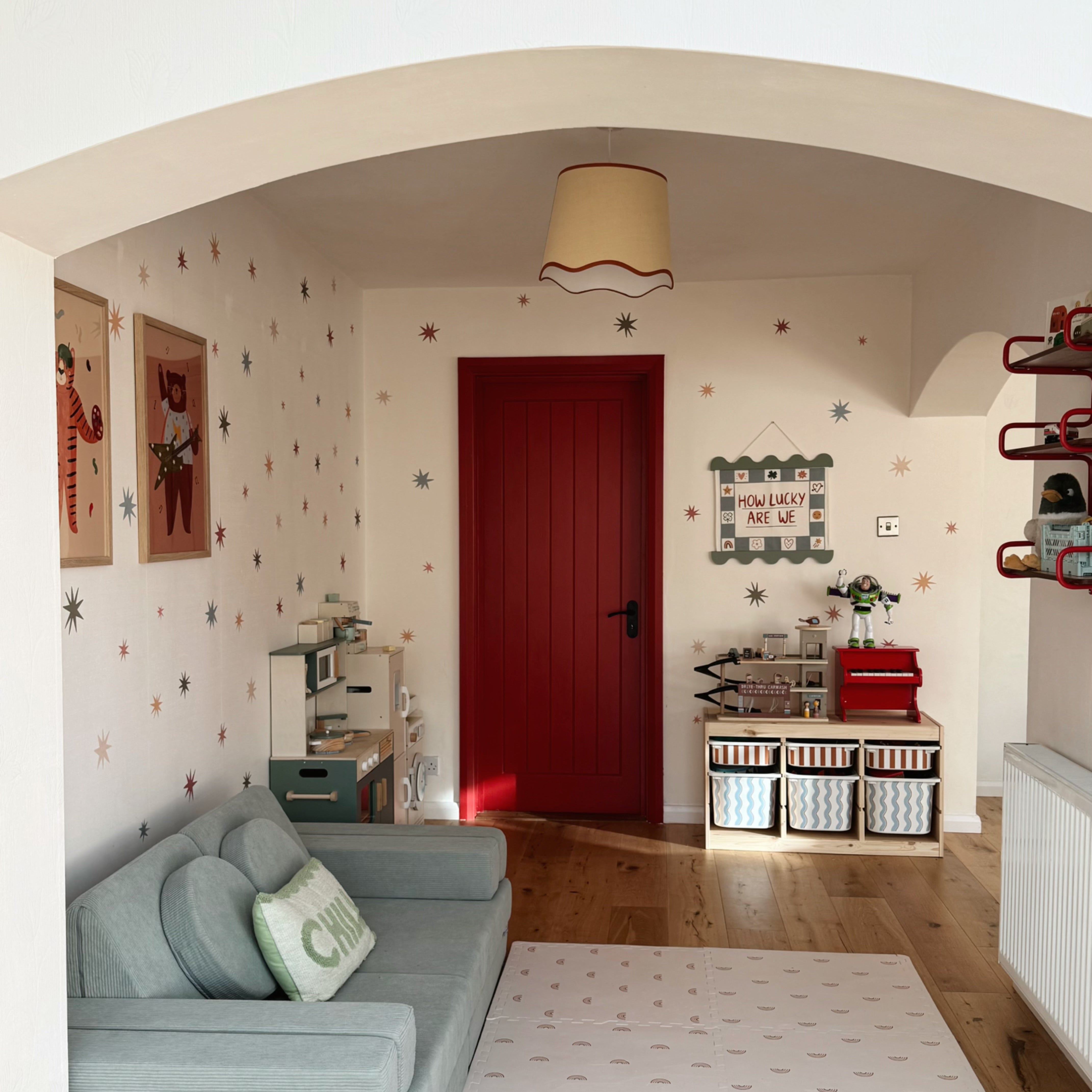 playroom room with green sofa, red door, and gus and beau mat